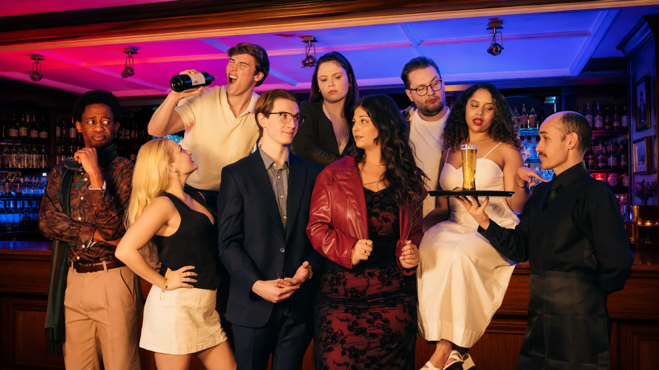 The full cast of First Date The Musical, gathered at a bar under neon lights